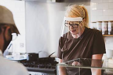 Waitress wearing face mask working in a cafe