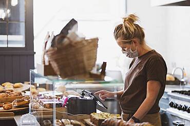 Waitress wearing face mask working in a cafe