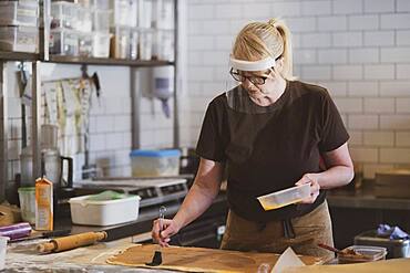 Waitress wearing face mask working in a cafe, preparing food