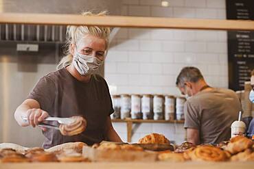 Waitress wearing face mask working in a cafe