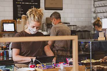 Waitress wearing face mask working in a cafe