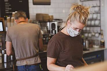 Waitress wearing face mask working in a cafe