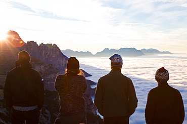 Group of young men watching the sunrise above the clouds, Trentino-Alto Adige, South Tyrol in Bolzano district, Alta Pusteria, Hochpustertal,Sexten Dolomites, Italy