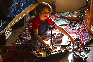 Overhead view of young boy in his room playing with his toys