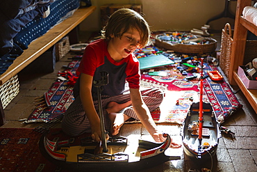 Overhead view of young boy in his room playing with his toys