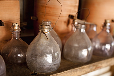 A row of glass jars, with stoppers and large clay pots on a shelf, Maryland, USA