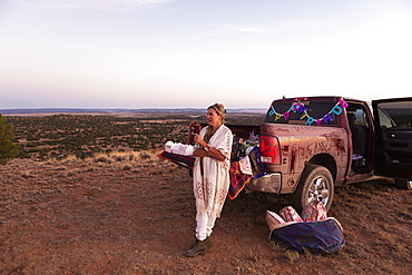 adult woman leaning on pickup truck at sunset, Galisteo Basin