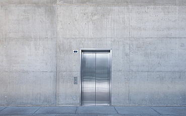 Metal elevator doors in a concrete wall