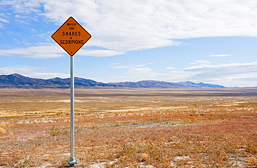 Warning sign of snakes and scorpions in grassland