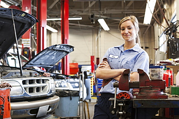 Portrait of young female Caucasian mechanic in auto repair shop