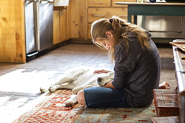 Teenage girl stroking her English Cream Golden Retriever dog