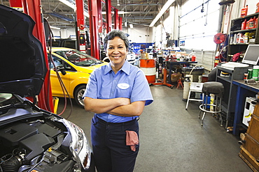 Portrait of female hispanic mechanic in auto repair shop