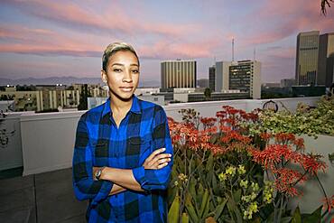 Young woman on a city rooftop at dusk