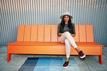 Young mixed race woman in a panama hat seated