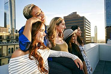 A group of young women partying on a city rooftop at dusk