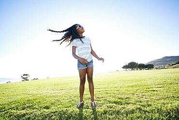 Young mixed race girl fanning her long black hair out by shaking her head