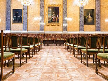 A large room with rows of chairs and chandeliers, part of the Museum of Fine Arts in Budapest