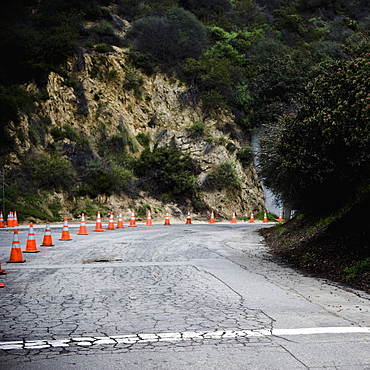 Cones on rural highway with cracked asphalt