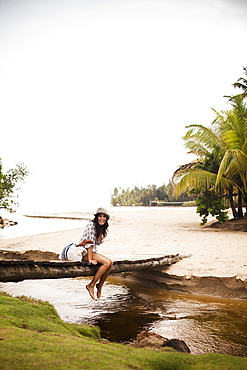 A young woman on a wooden bridge over a small creek on Samana Peninsula in the Dominican Republic, Samana Peninsula, Dominican Republic.