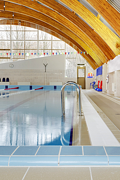 Roof beams under a curved roof over an indoor swimming pool.