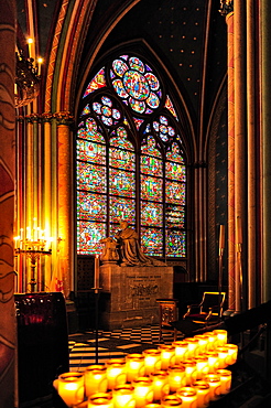 Interior of Notre Dame cathedral in Paris, before the fire of 2019, a stained glass window and rows of lit candles, Paris, France