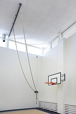 Indoor sports hall in a school, climbing ropes attached to the ceiling.