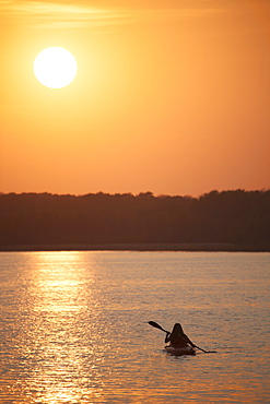 Kayaker at sunset on a calm lake, Kayaking at sunset, Saskatchewan, Canada