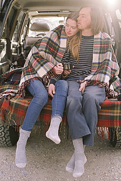 Young couple sitting in the back of their car, Millcreek, Utah, United States of America