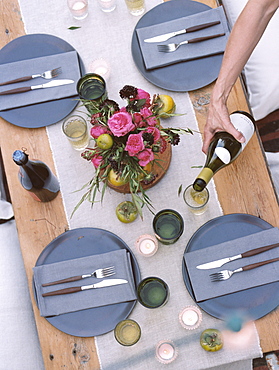 An apple orchard in Utah. A set table, a person pouring a glass of wine, Sataquin, Utah, United States of America