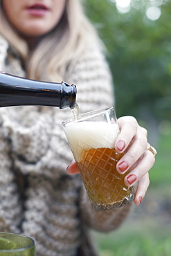 An apple orchard in Utah. Woman pouring a glass of cider, Sataquin, Utah, United States of America