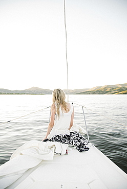 Blond teenage girl sitting on sail boat.