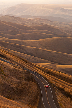 A view looking down of a car moving on a highway at sunrise near Lewiston, Idaho USA, United States of America