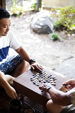 High angle view of two Japanese men sitting on floor, playing Go, Kyushu, Japan