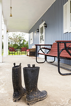 Dirty wellingtons on front porch, Mendon, New York, USA