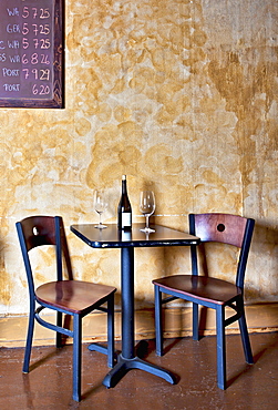 Bottle of wine and glasses on table in wine bar, Oregon, Washington, USA