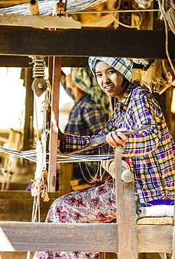 Asian girl weaving fabric