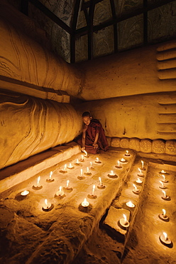 Asian monk lighting candles in temple