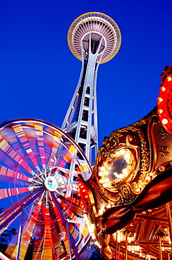 Low angle view of Space Needle, ferris wheel and carousel under night sky, Seattle, Washington, United States