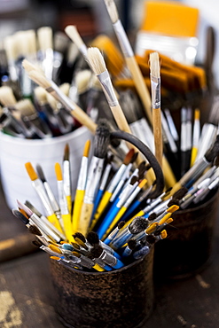 High angle close up of tins with selection of paintbrushes in various sizes, Oxfordshire, England