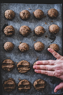 High angle close up of person putting chocolate cookie dough on a baking tray, England