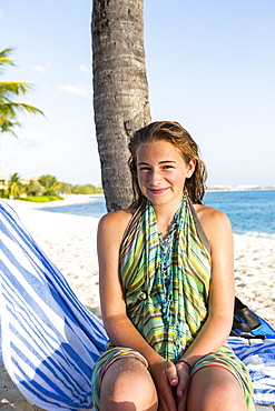 A teenage girl sitting in a beach chair, Grand Cayman, Cayman Islands