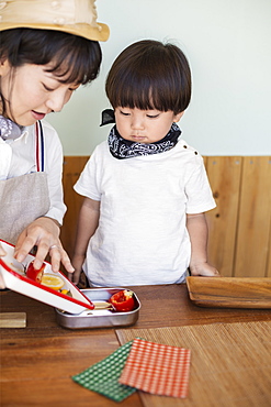 Japanese woman and boy standing in a farm shop, preparing food, Kyushu, Japan