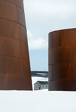 Tall rusting metal whale oil tanks at the former whaling station on Deception Island, Deception Island, South Shetland Islands, Antarctica