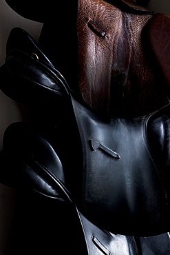 Close up of a selection of black and brown leather saddles, Berkshire, United Kingdom