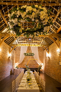 Long dining table with festive place settings for a naming ceremony in an historic barn