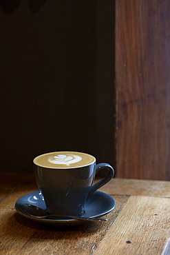 Close up of cup of Cappuccino on a rustic wooden table in a cafe