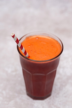 High angle close up of glass of beetroot smoothie in a cafe