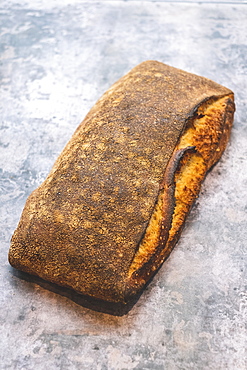 Artisan bakery making special sourdough bread, a baked loaf with firm dark crust