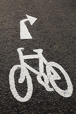 High angle close up of white bicycle lane sign on concrete path