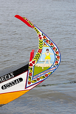 Traditional moliceiro fishing boat with a high prow, painted in vivid colours and with distinctive patterns, Ria de Aveiro Lagoon Portugal